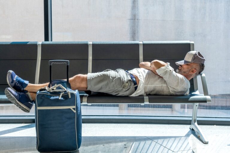 man sleeping at airport with jet lag